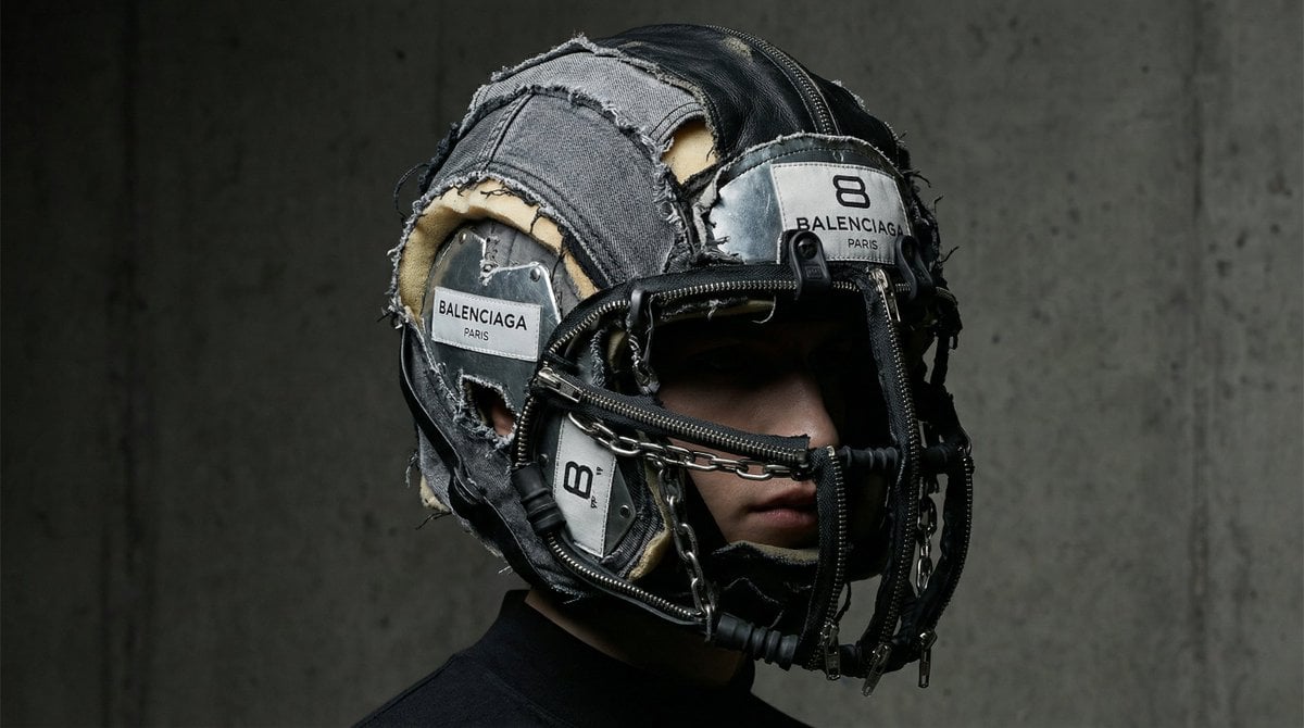 [BRAND]. A hyperrealistic editorial photo of a figure wearing a unique helmet or