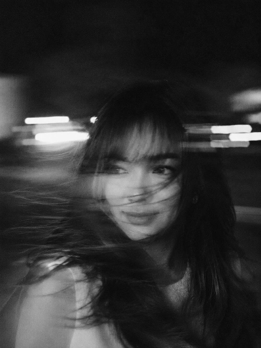 A hyper-realistic, cinematic black-and-white portrait of a woman caught in mid-m
