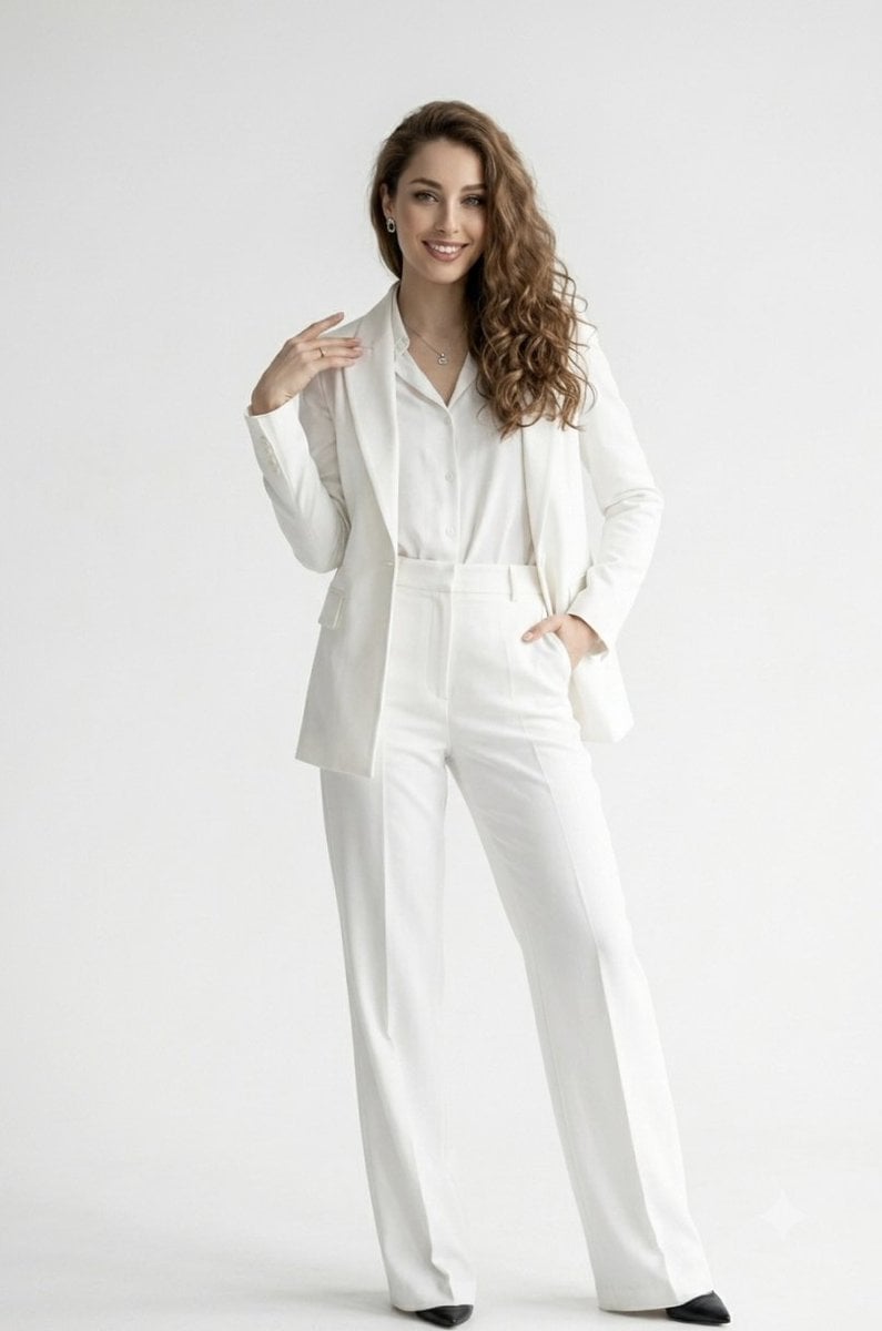 A full-length studio portrait of a confident, smiling woman with long, wavy brow