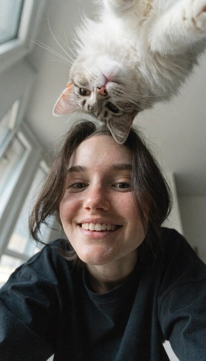 Create a realistic vertical smartphone selfie taken indoors from a very low floo
