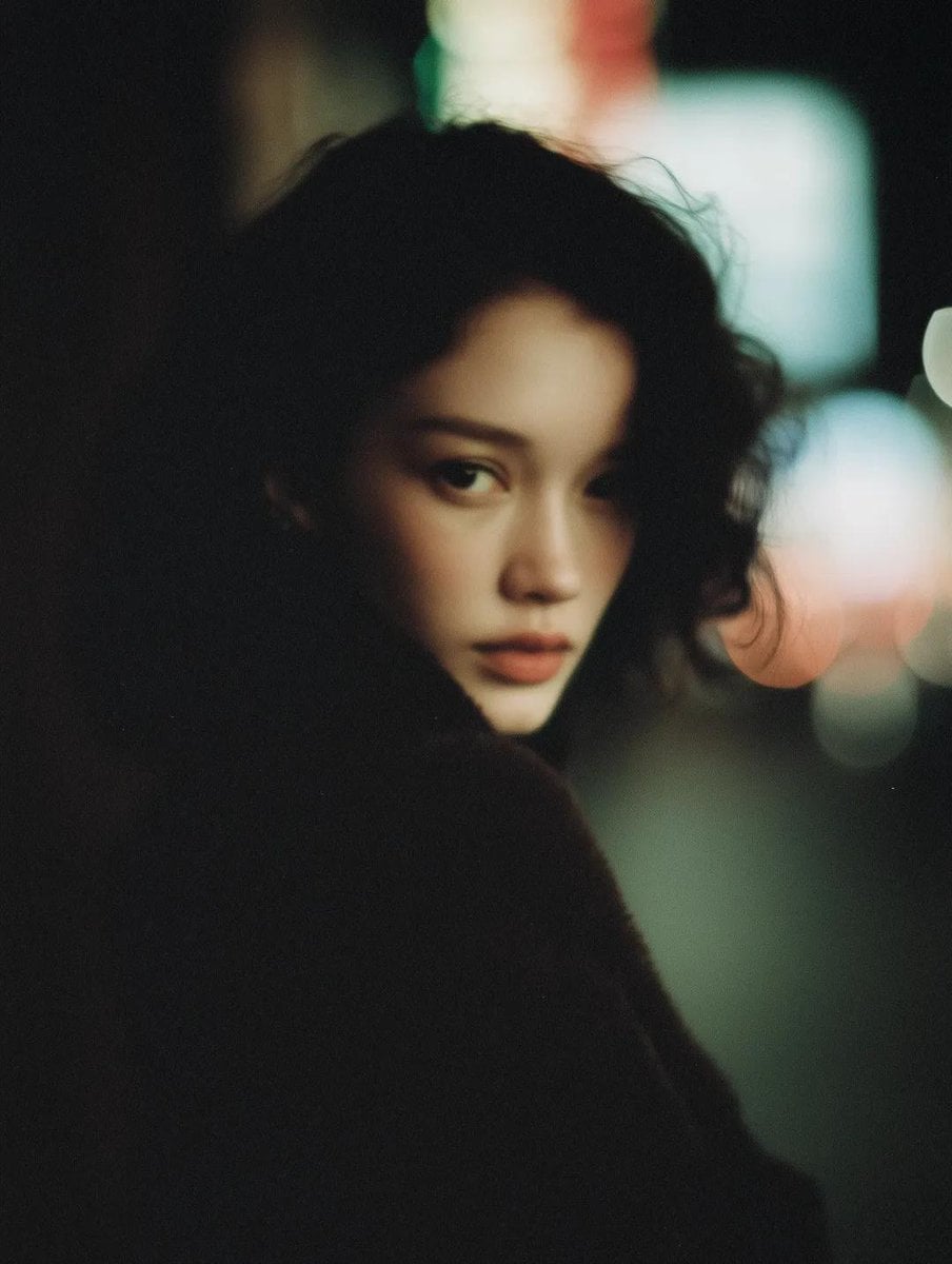 Cinematic, intimate portrait of a young woman with short dark wavy hair, natural