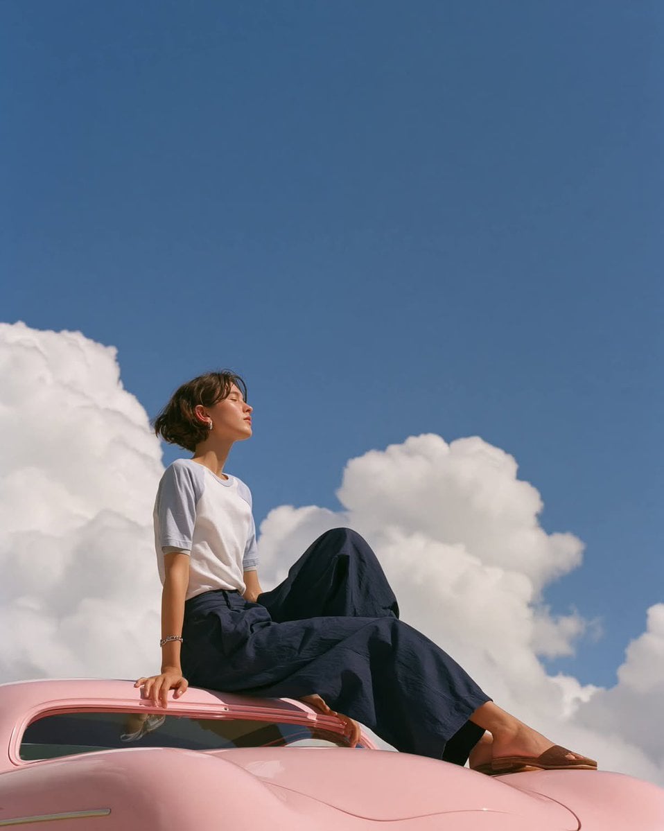 soft, dreamlike editorial fashion photo of a minimalist young woman posed gracef