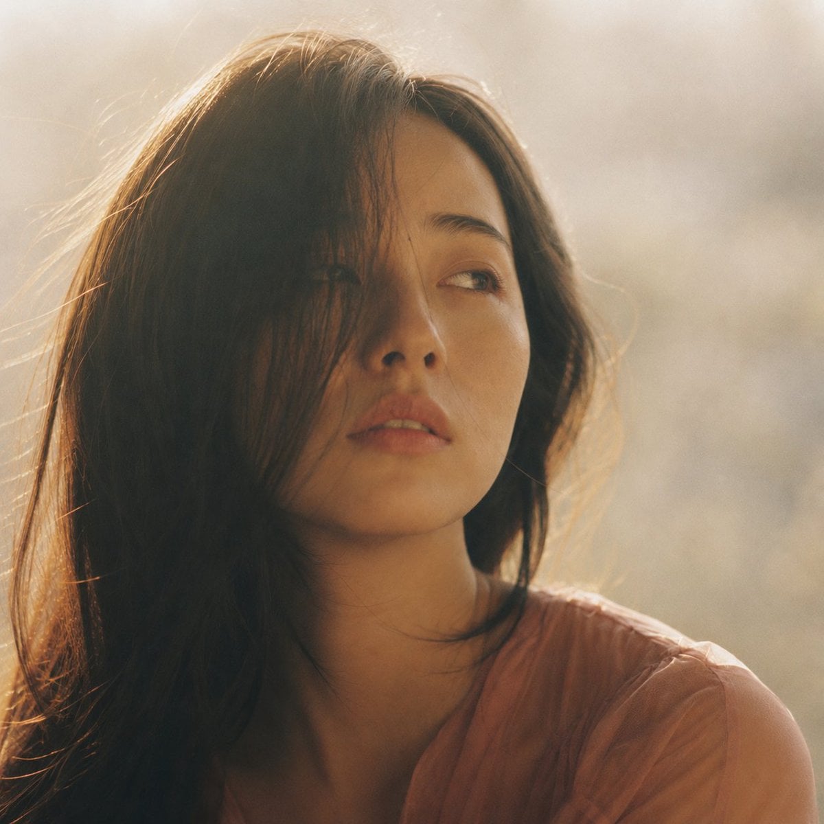 Portrait shot on 85mm f/1.4, square crop close-up of a Japanese woman in her ear