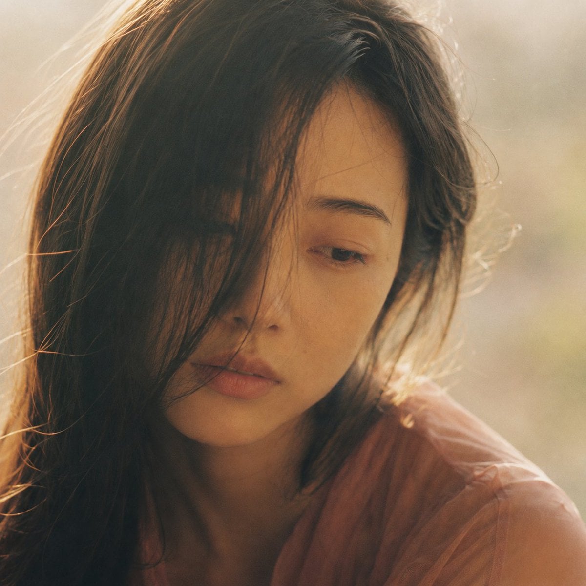 Portrait shot on 85mm f/1.4, square crop close-up of a Japanese woman in her ear