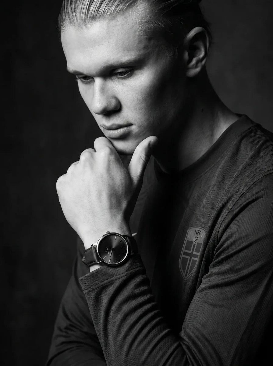 Create an ultra-realistic black-and-white editorial portrait of the uploaded per